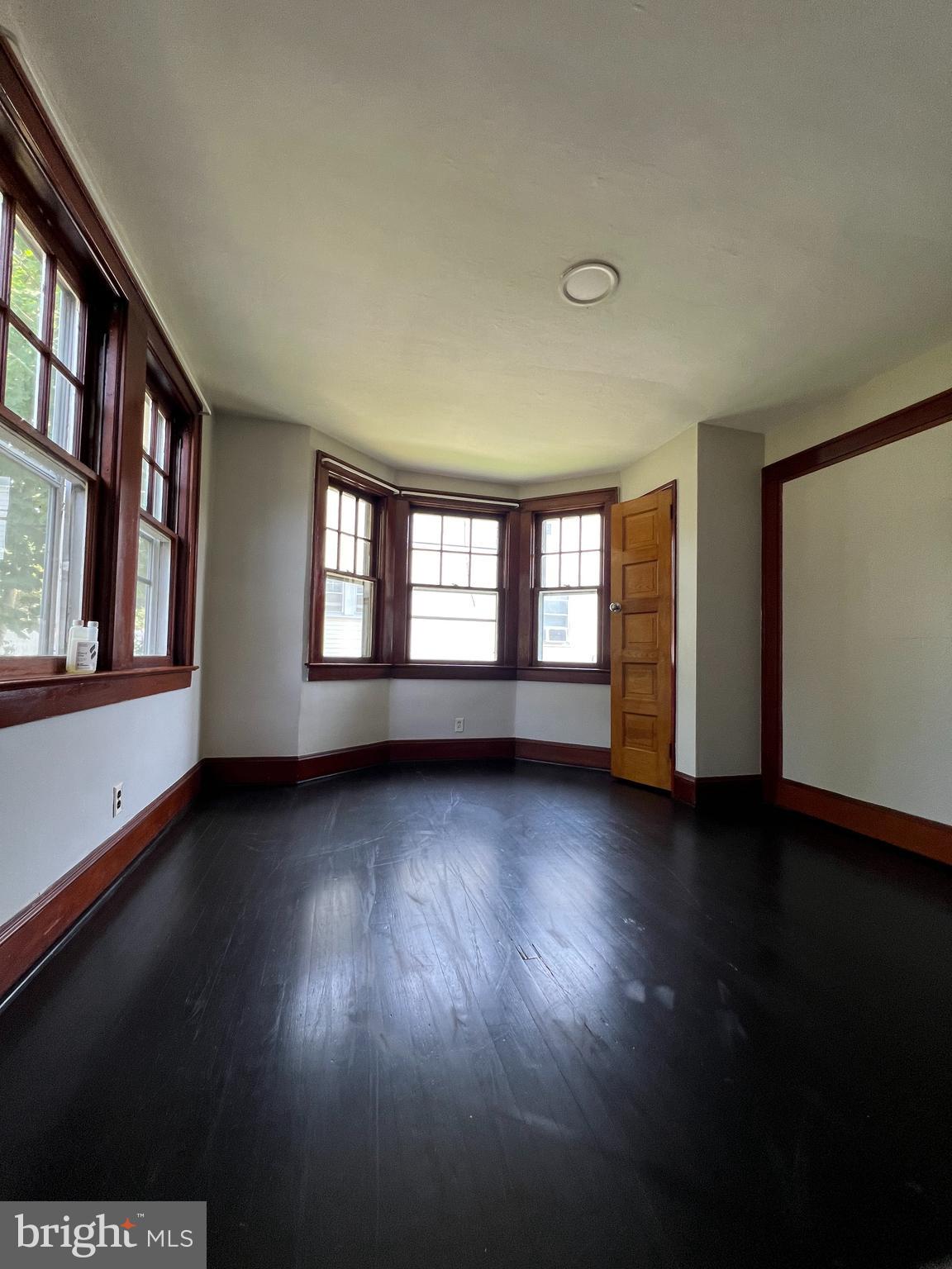8 Ewington Avenue, Unit 1 Ewing, NJ 08638 - Photo 4 of 5 a view of an empty room with a window and wooden floor