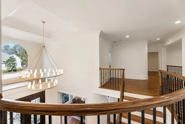 a bedroom with a bed a chandelier and chair