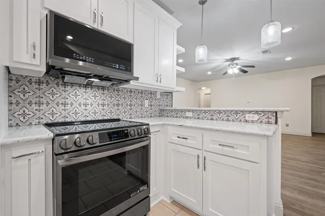 a kitchen with appliances a sink and cabinets