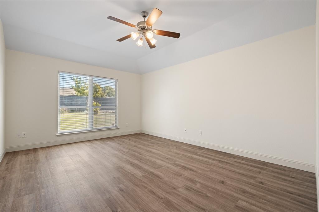 7103 Camp Creek Drive Arlington, TX 76002 - Photo 18 of 29 an empty room with wooden floor fan and windows