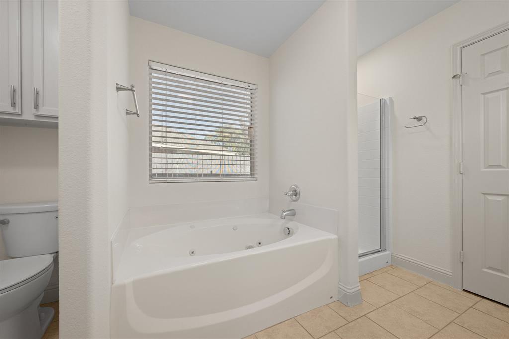 7103 Camp Creek Drive Arlington, TX 76002 - Photo 22 of 29 a white bath tub sitting next to a toilet