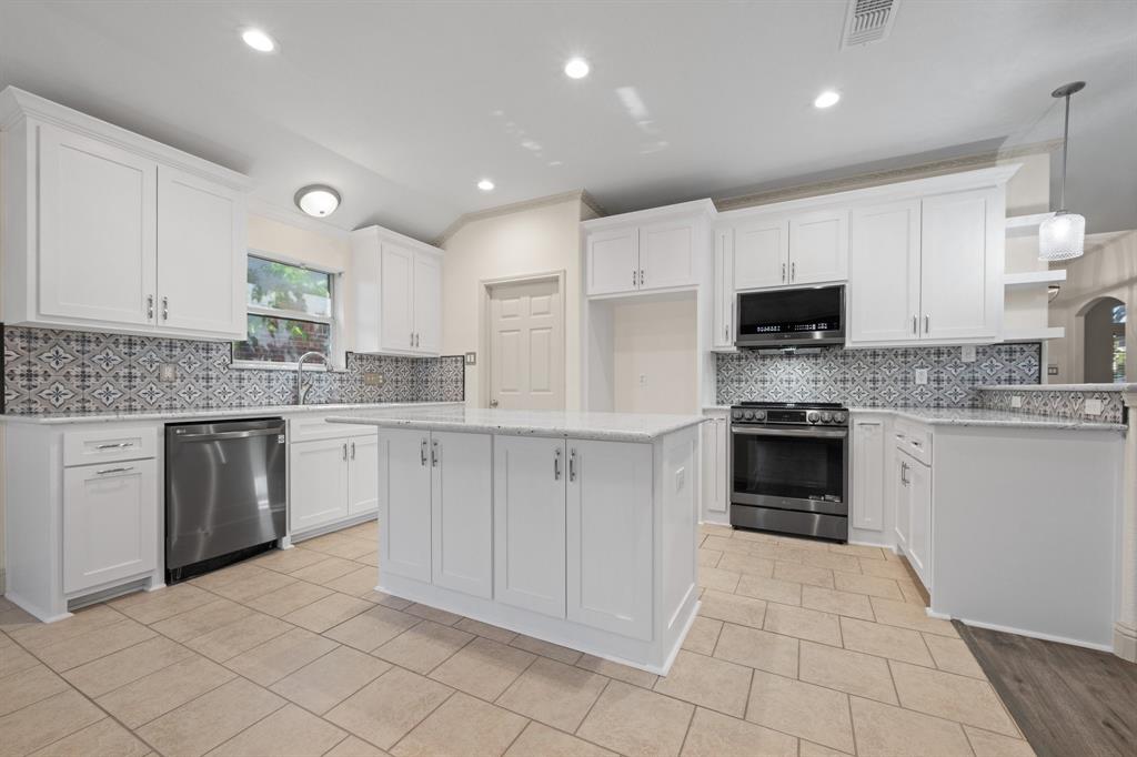7103 Camp Creek Drive Arlington, TX 76002 - Photo 8 of 29 a kitchen with kitchen island granite countertop a stove sink and cabinets