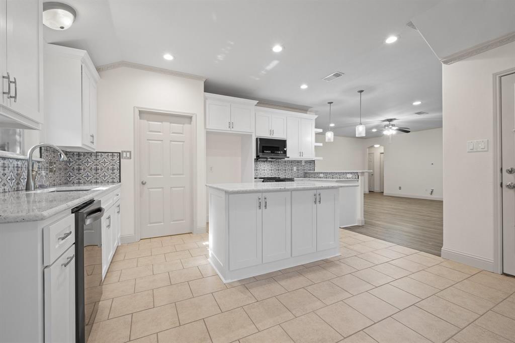7103 Camp Creek Drive Arlington, TX 76002 - Photo 9 of 29 a kitchen with kitchen island granite countertop appliances cabinets and a sink