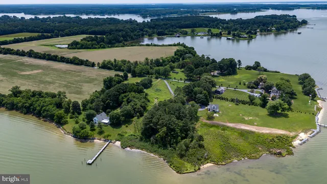 an aerial view of residential houses with outdoor space and lake view