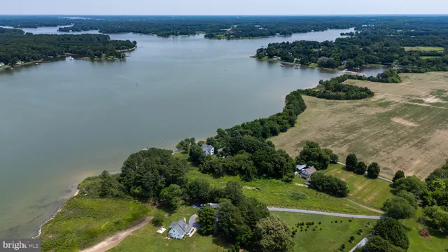 an aerial view of lake and residential houses with outdoor space and seating