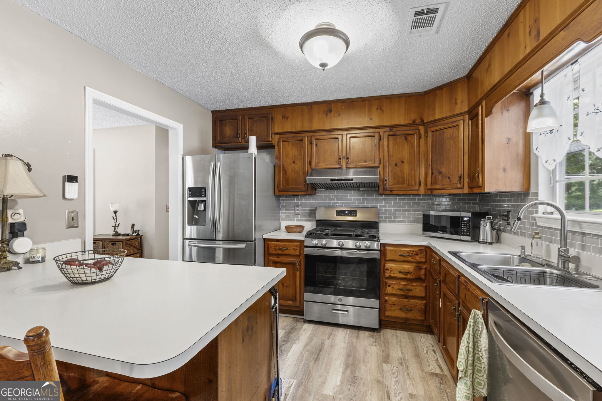305 North Lake Drive Perry, GA 31069 - Photo 11 of 32 a kitchen with stainless steel appliances a stove a sink a microwave and cabinets