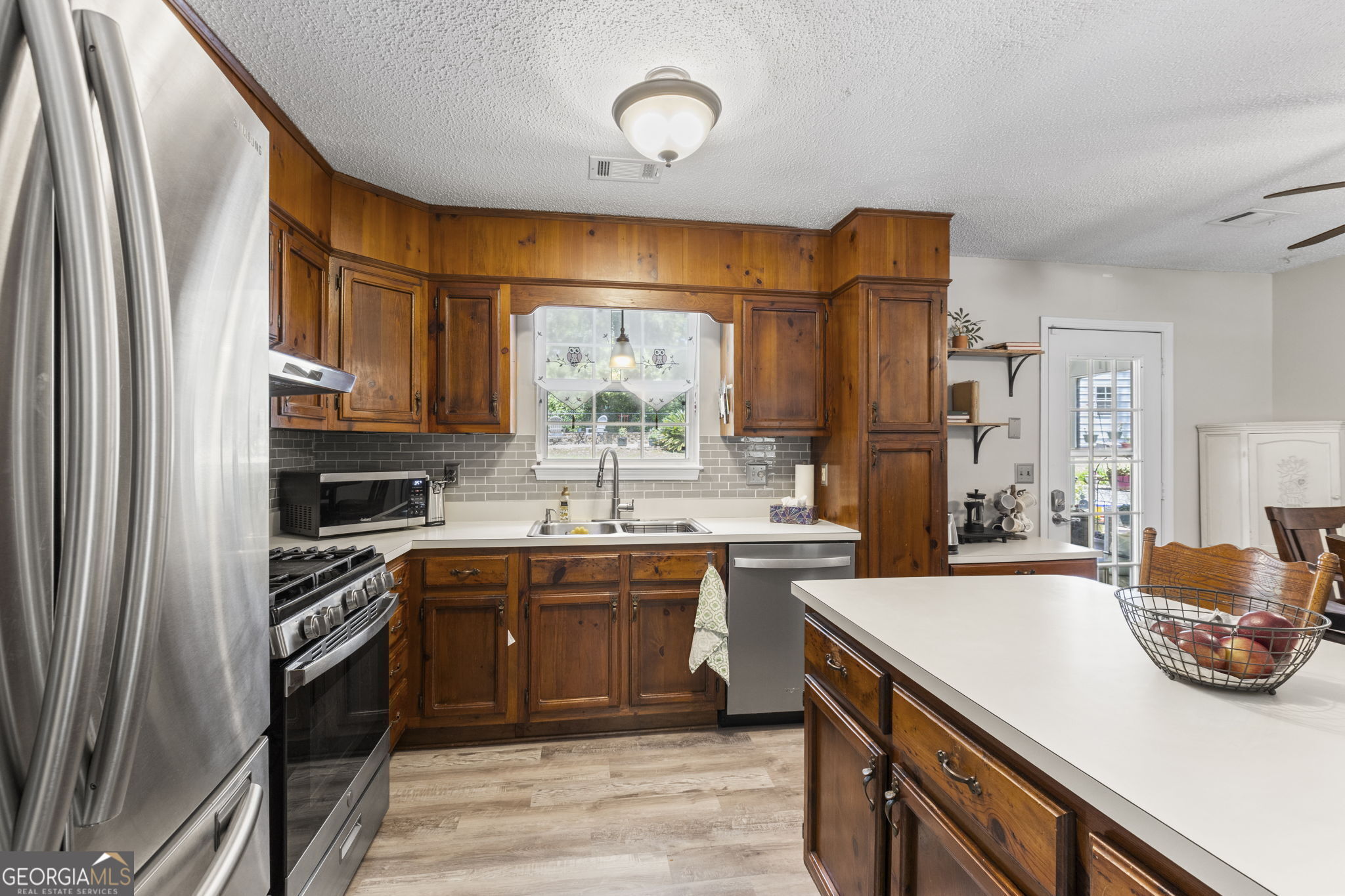 305 North Lake Drive Perry, GA 31069 - Photo 12 of 32 a kitchen with stainless steel appliances a sink stove and cabinets