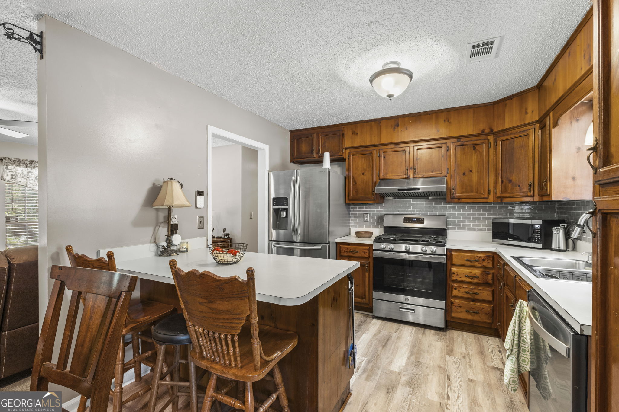 305 North Lake Drive Perry, GA 31069 - Photo 14 of 32 a kitchen with stainless steel appliances granite countertop a stove top oven a sink dishwasher and a refrigerator