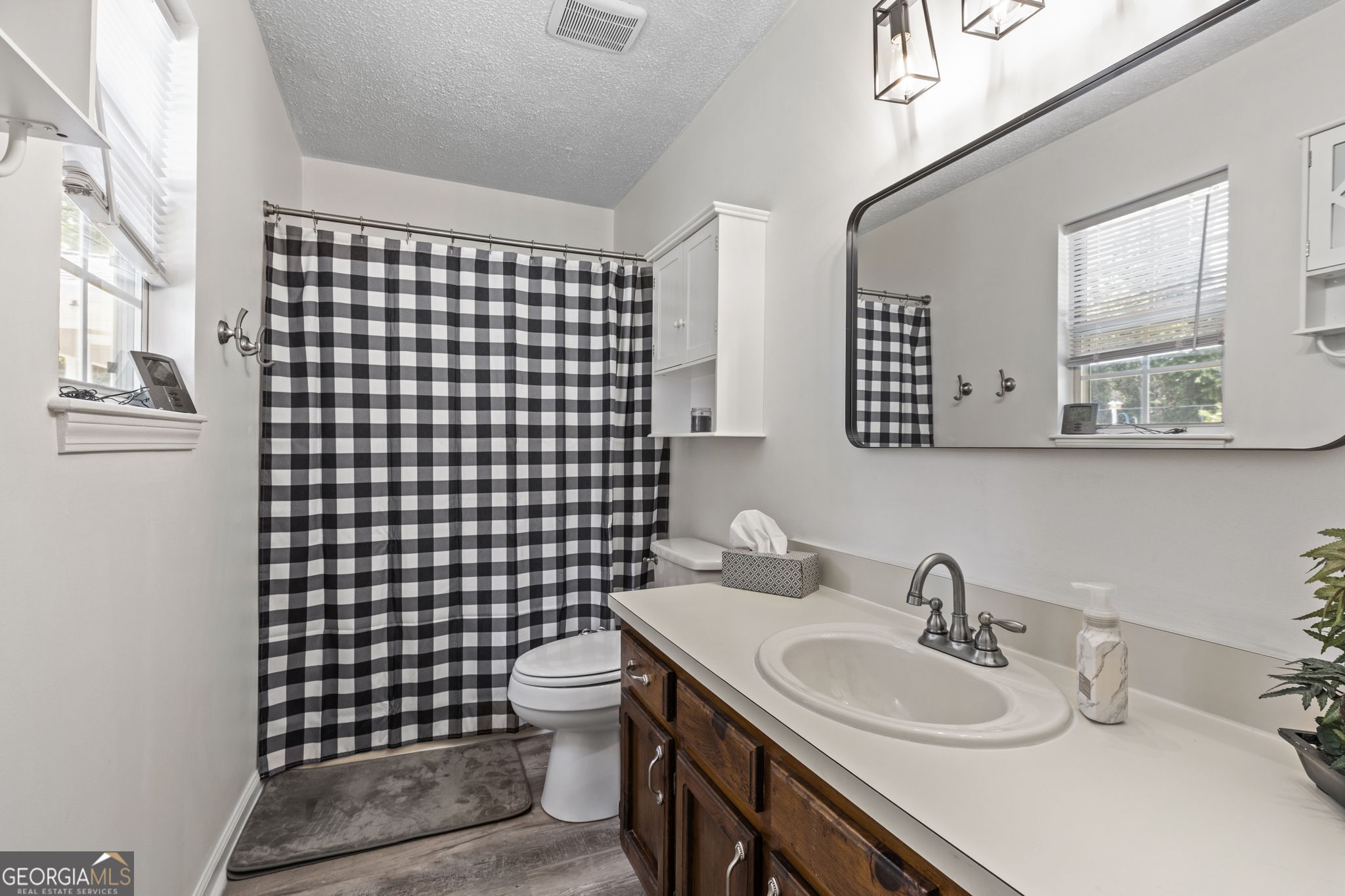 305 North Lake Drive Perry, GA 31069 - Photo 19 of 32 a bathroom with a sink toilet a mirror and shower