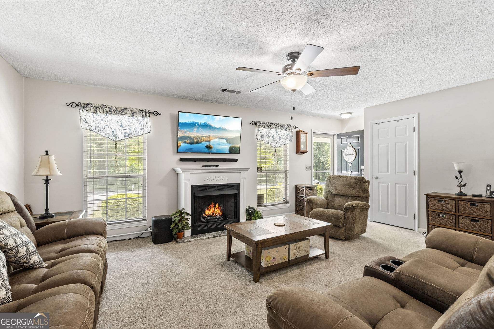 305 North Lake Drive Perry, GA 31069 - Photo 8 of 32 a living room with furniture a flat screen tv and a fireplace
