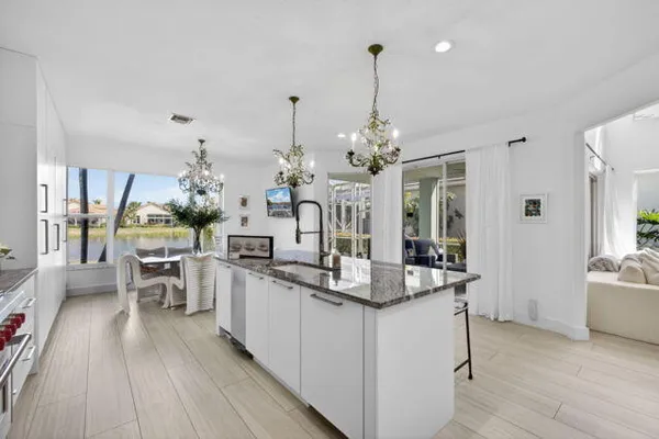 a view of a dining room kitchen with furniture wooden floor and chandelier