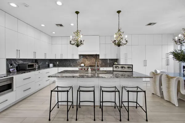 a kitchen with kitchen island granite countertop a table and chairs in it