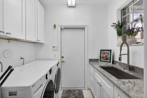 a kitchen with granite countertop a sink a stove and cabinets