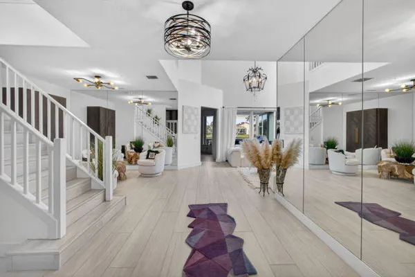 a view of a hallway with dining room and chandelier