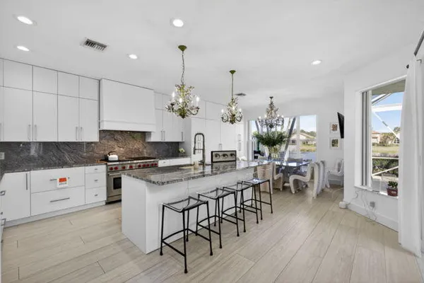 a kitchen with stainless steel appliances a table and chairs in it