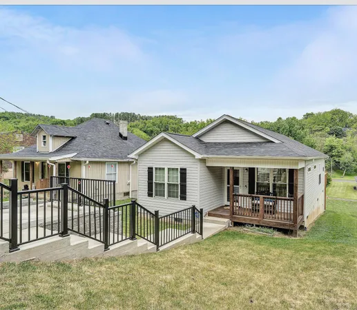 a view of a house with wooden deck and a backyard