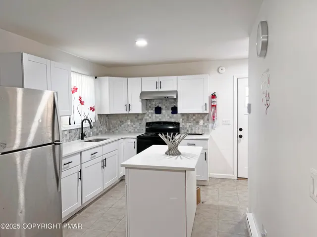 a kitchen with a sink refrigerator and cabinets