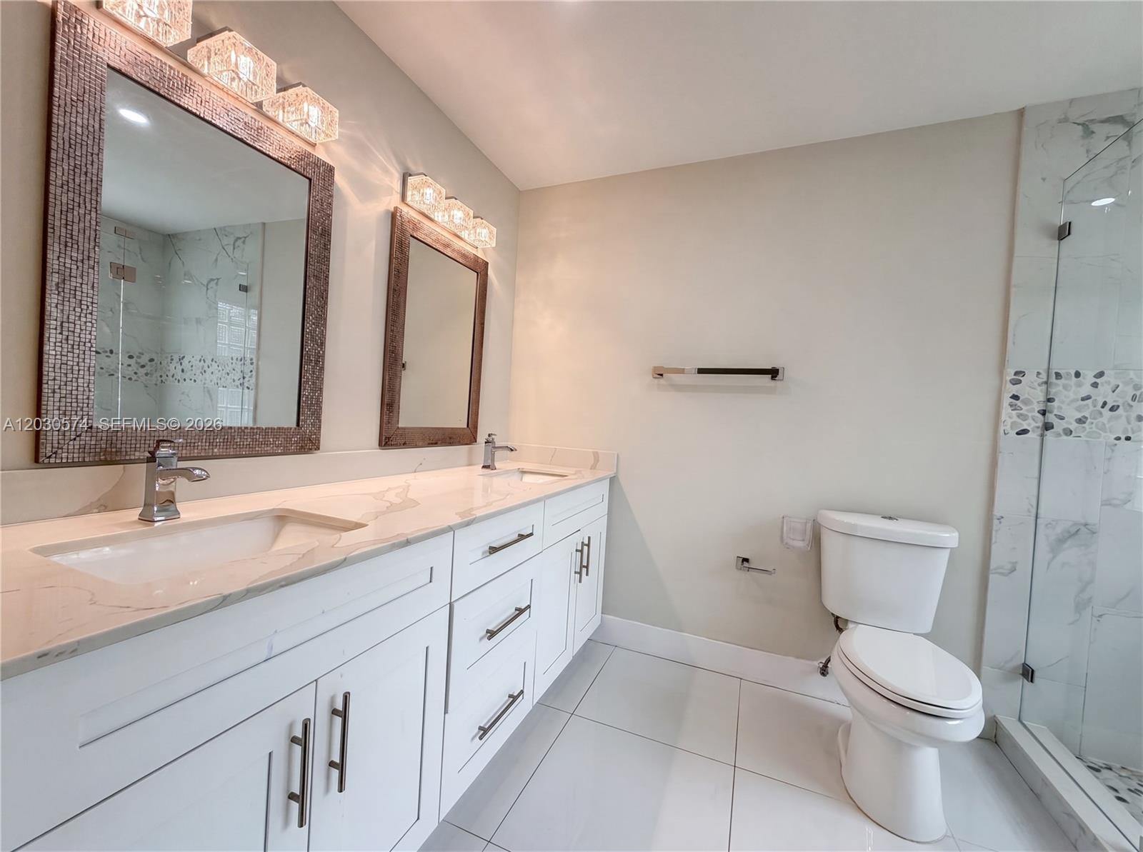 16571 Southwest 145th Avenue Miami, FL 33177 - Photo 12 of 25 a bathroom with double vanity sink a mirror and a toilet