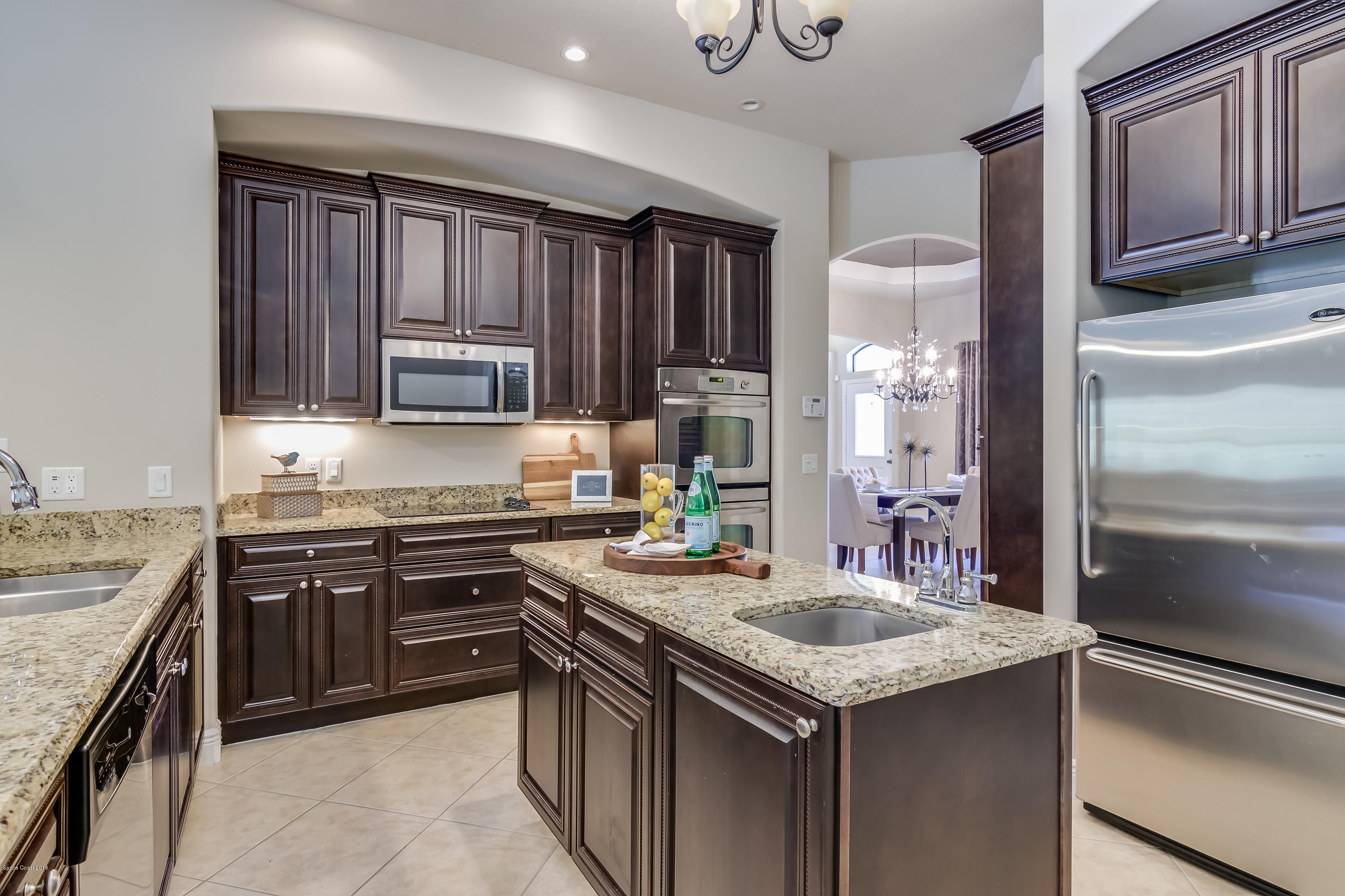4025 Waterloo Place Melbourne, FL 32940 - Photo 11 of 29 a kitchen with kitchen island granite countertop a sink stove and refrigerator