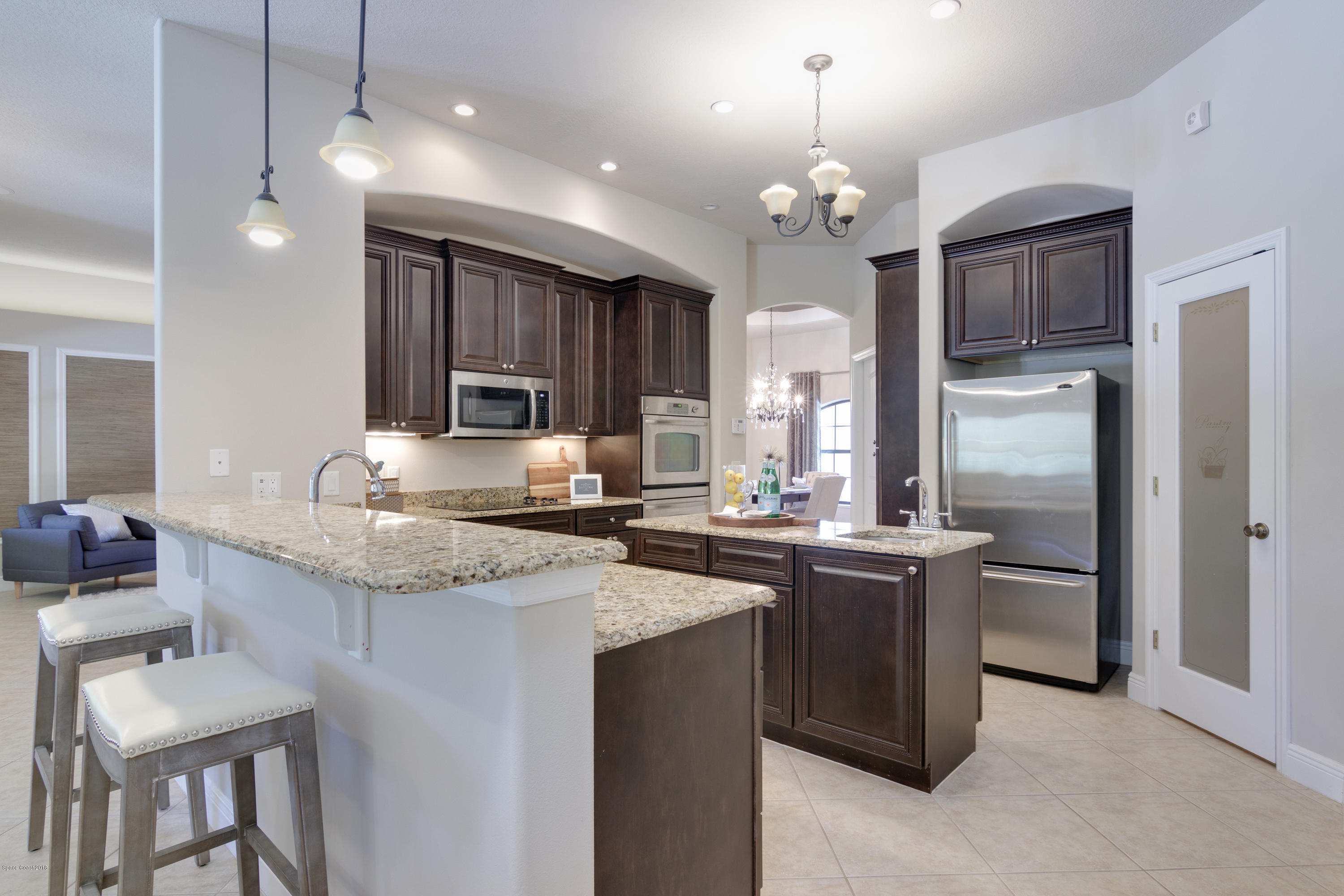 4025 Waterloo Place Melbourne, FL 32940 - Photo 12 of 29 a kitchen with kitchen island granite countertop a sink stove and refrigerator