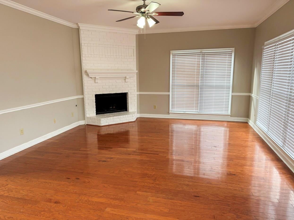 8810 Raspberry Lane Memphis, TN 38016 - Photo 11 of 28 Unfurnished living room with baseboards, crown molding, wood finished floors, and ceiling fan