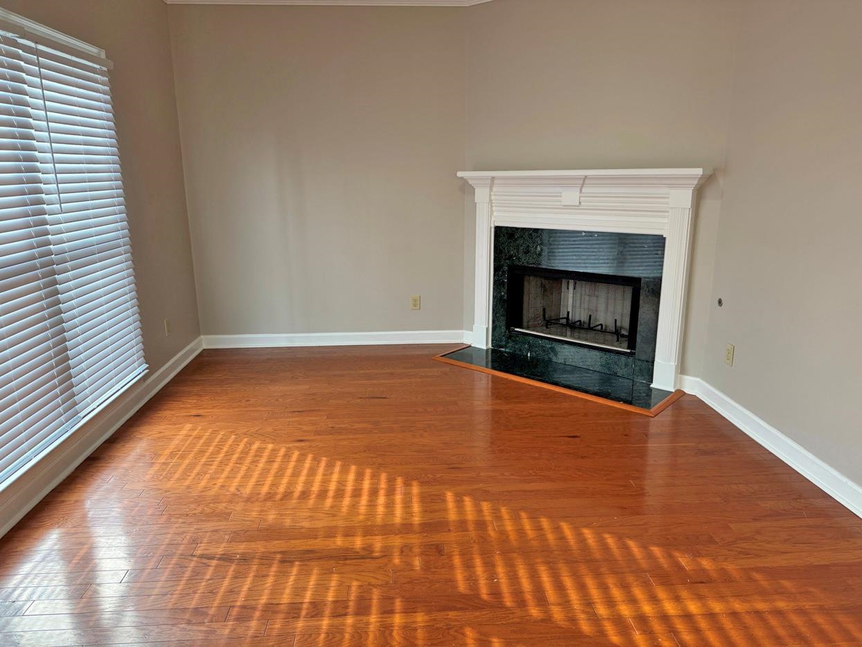 8810 Raspberry Lane Memphis, TN 38016 - Photo 12 of 28 Unfurnished living room featuring baseboards, a high end fireplace, and wood finished floors