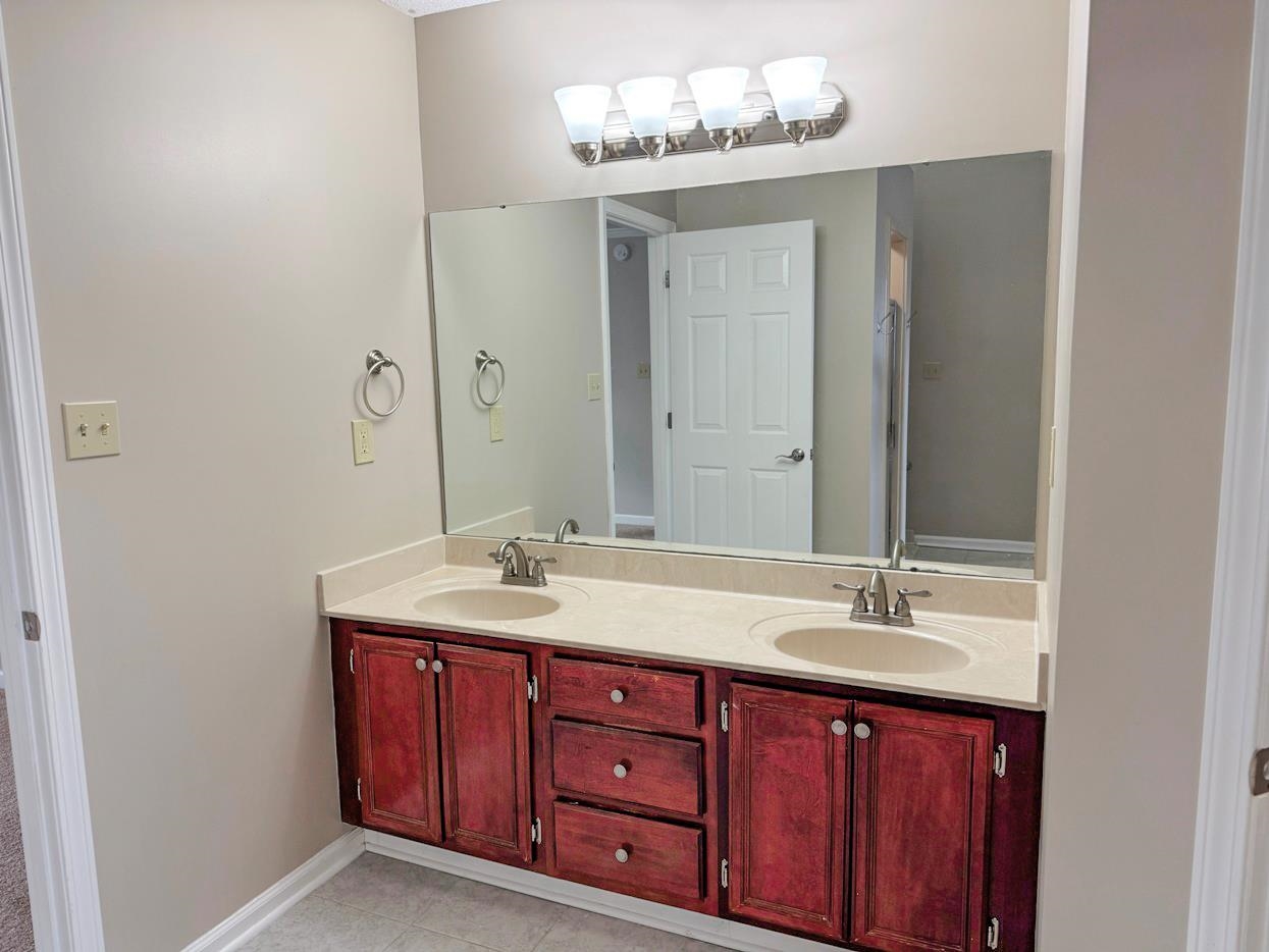 8810 Raspberry Lane Memphis, TN 38016 - Photo 19 of 28 Full bath with double vanity, tile patterned flooring, a sink, and baseboards