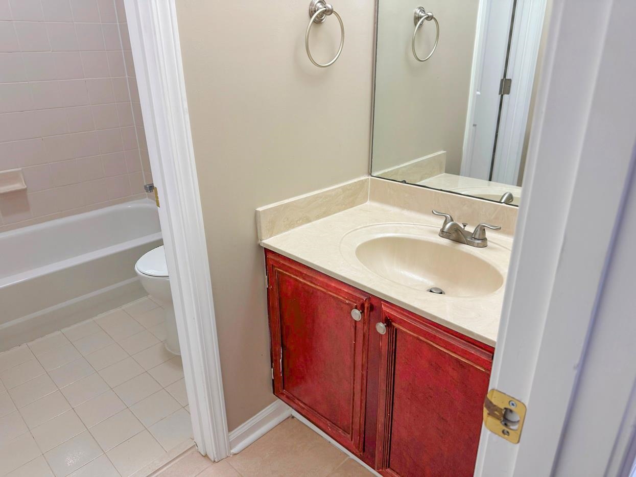 8810 Raspberry Lane Memphis, TN 38016 - Photo 28 of 28 Full bathroom with toilet, tile patterned floors, vanity, and shower / washtub combination
