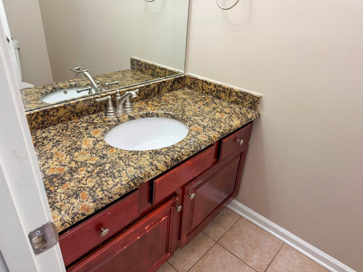 8810 Raspberry Lane Memphis, TN 38016 - Photo 6 of 28 Half bath with baseboards, tile patterned flooring, and vanity