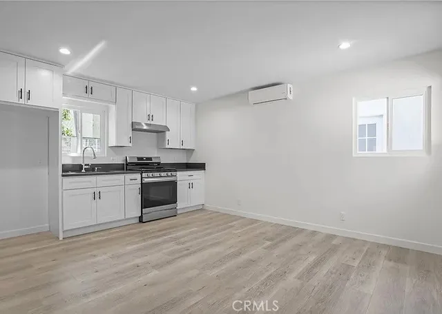 a kitchen with granite countertop white cabinets and white appliances
