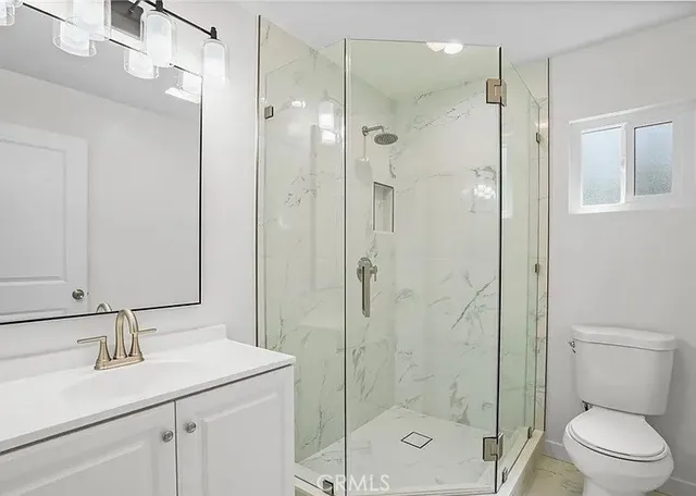a bathroom with a shower sink vanity mirror and toilet