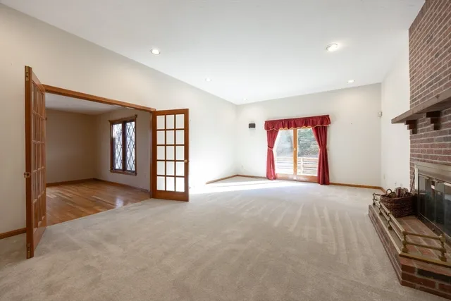 a view of an empty room with a window and fireplace