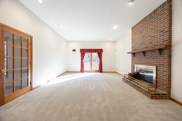 a view of an empty room with a fireplace and a window