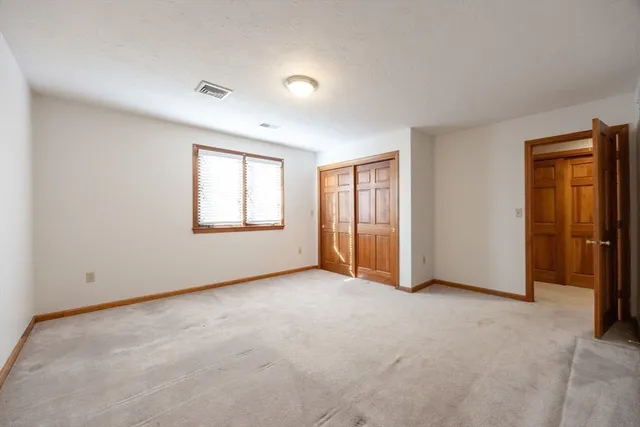an empty room with windows and closet