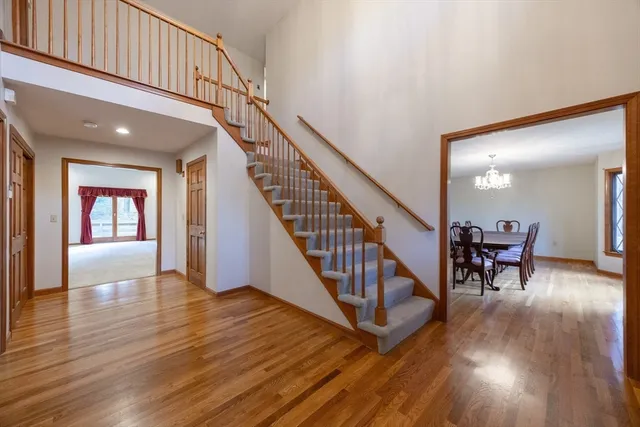a view of staircase with wooden floor and a chandelier