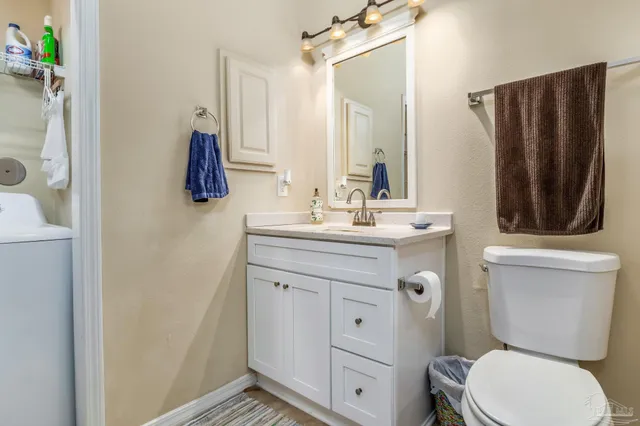 a bathroom with a sink a toilet a mirror and shower curtain