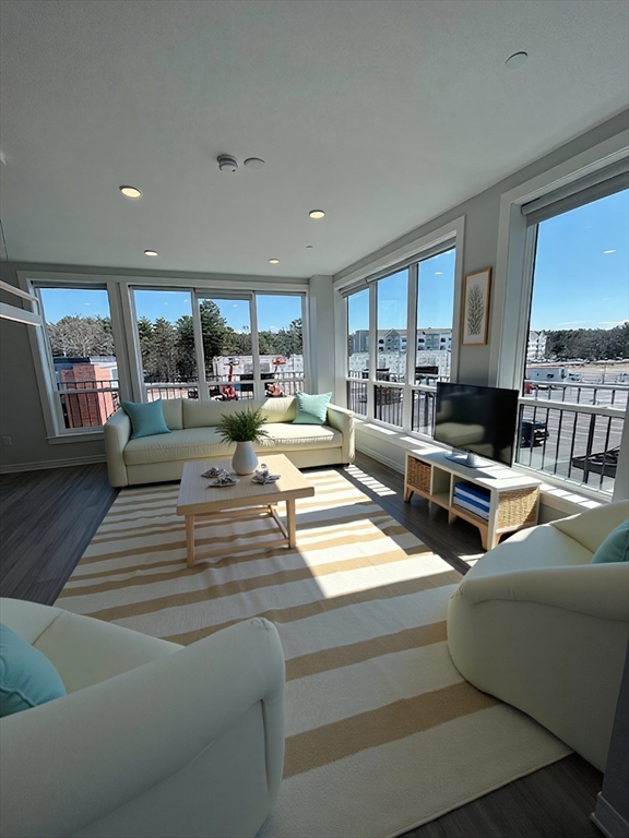 148 Old Post Road, Unit 218 Sharon, MA 02067 - Photo 2 of 17 a living room with furniture kitchen view and large windows