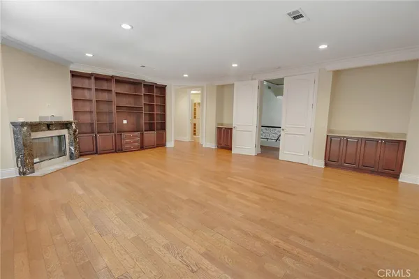 an empty room with cabinet and windows
