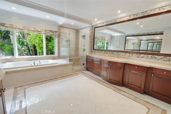 a spacious bathroom with a tub sink and mirror