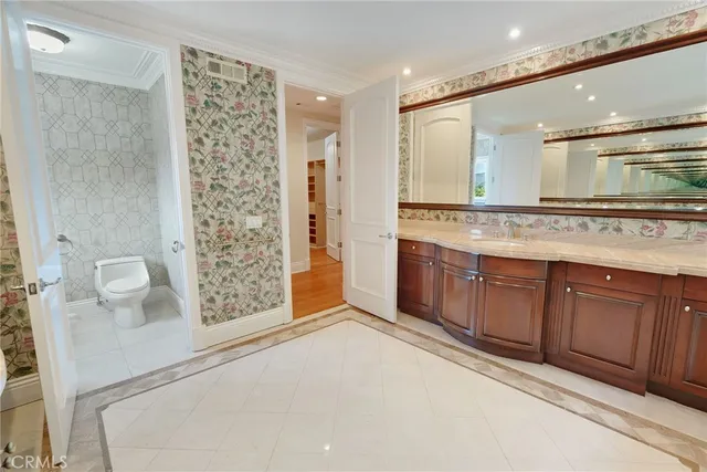 a bathroom with a granite countertop sink a toilet a mirror and shower