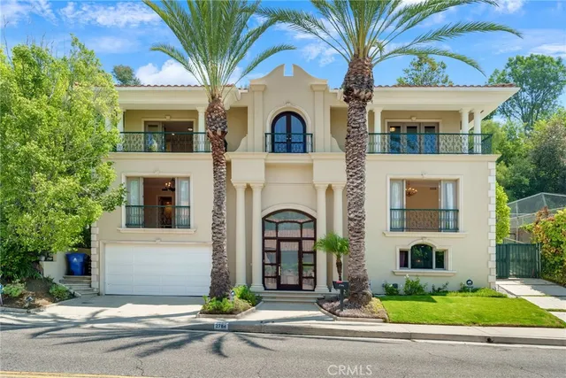 a view of a white house with large windows and a small yard