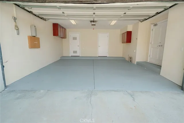 an empty room with wooden floor chandelier and windows