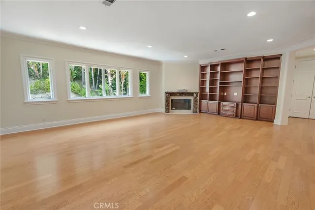 an empty room with a empty shelves and large window