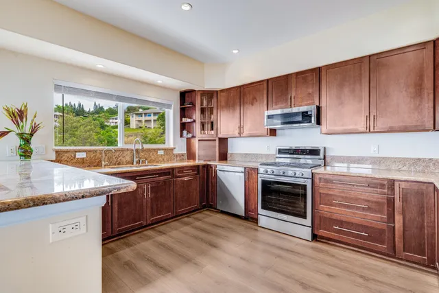 a kitchen with stainless steel appliances granite countertop a stove a sink and a microwave