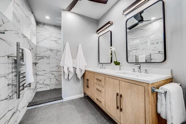 a bathroom with a double vanity sink a mirror and a shower
