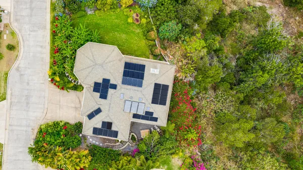 an aerial view of a house with swimming pool and large trees