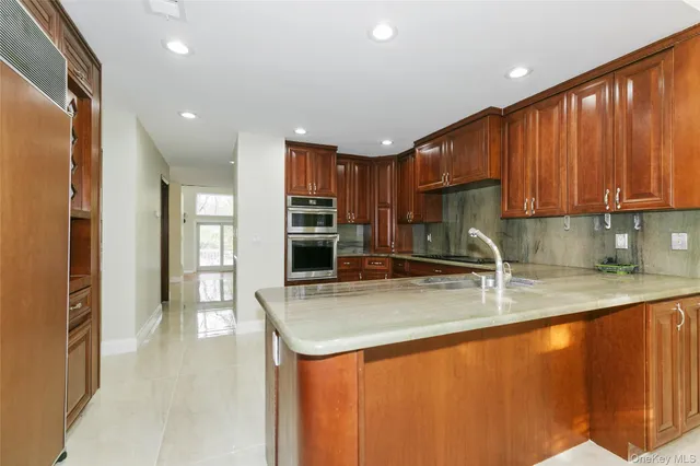 a kitchen with granite countertop a refrigerator and a sink