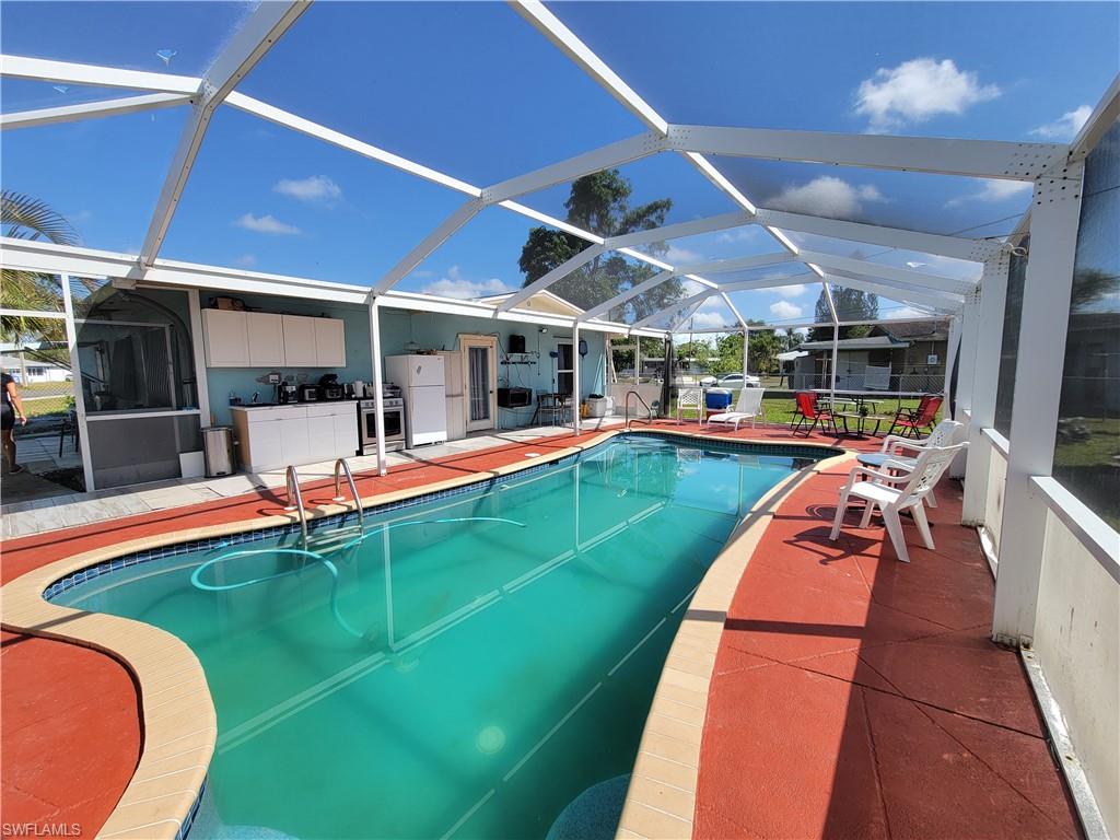 10 East Jersey Road Lehigh Acres, FL 33936 - Photo 1 of 32 Pool with a patio and glass enclosure
