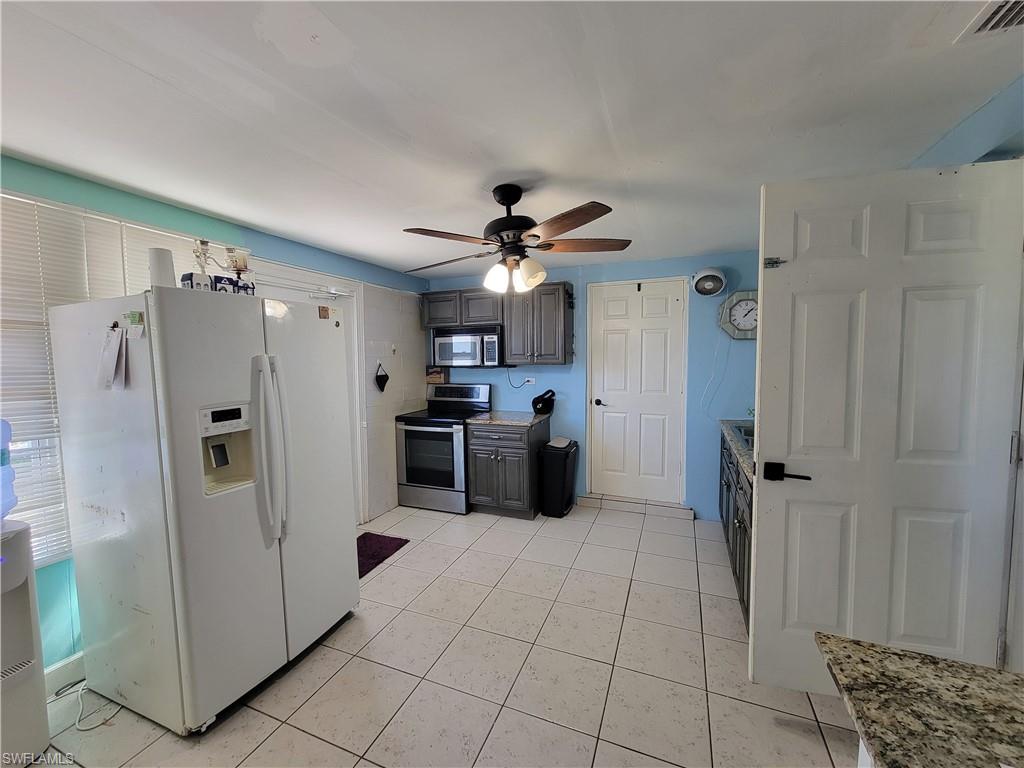 10 East Jersey Road Lehigh Acres, FL 33936 - Photo 17 of 32 Kitchen with visible vents, appliances with stainless steel finishes, light tile patterned flooring, and a ceiling fan