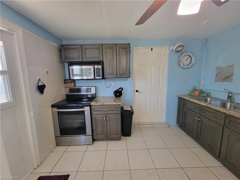 10 East Jersey Road Lehigh Acres, FL 33936 - Photo 19 of 32 Kitchen with a sink, light tile patterned floors, appliances with stainless steel finishes, and a ceiling fan